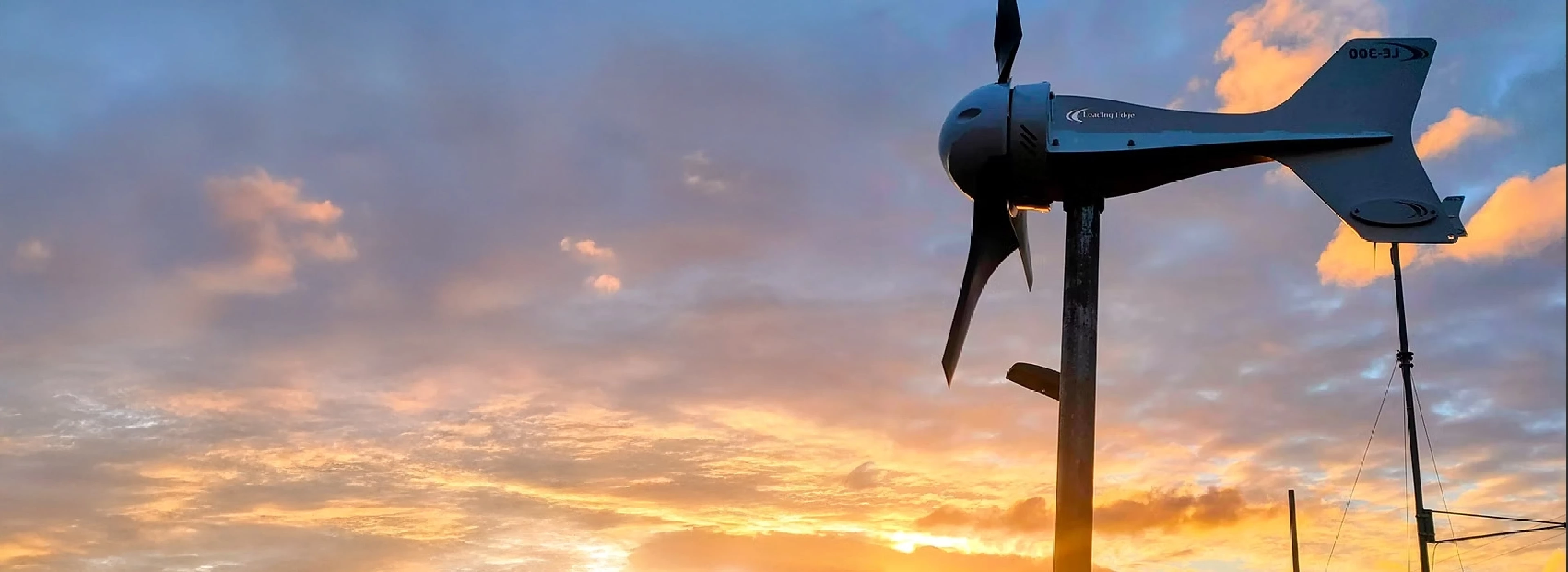 Leading Edge wind turbine powering remote IoT telemetry unit at dusk